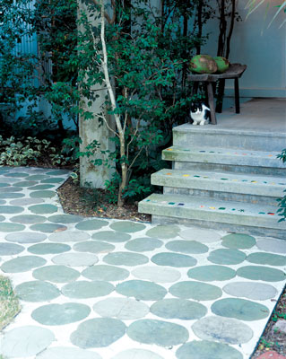 
The porch, decorated with colorful tiles, overlooks a patio of giant clay seagrape leaves made by the homeowners.
